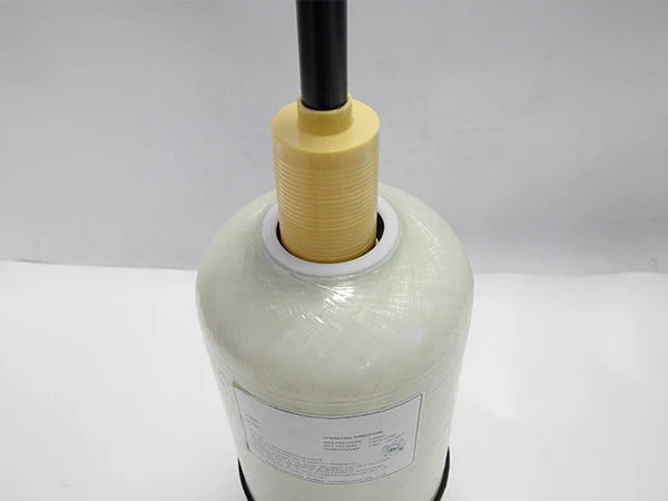 A worker is putting the central tube into the softener tank.